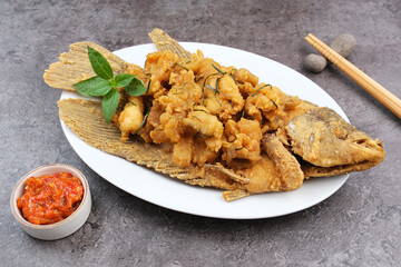 Gurame Saos Telur Asin. Crispy fried gourami fish covered with salted egg sauce. Indonesian food
