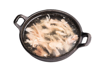 Chicken broth with meat in a skillet isolated on white background. top view