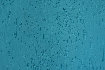 Close shot of turquoise blue wall with stucco worm finish