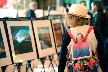 Young woman with colorful backpack on art exhibition