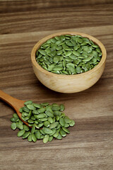 Fresh pumpkin seeds in wooden bowl