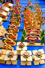 Naklejka premium Colorful Wooden Crafts Featuring Hearts and Flowers at a Market Display