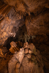 Remarkable formations of stalactites and stalagmites create an enchanting display in a dimly lit...
