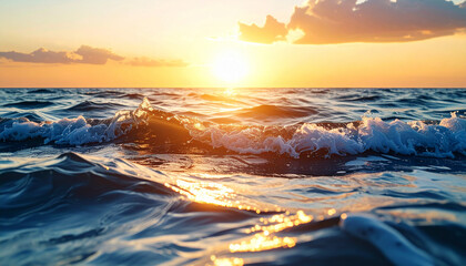 Beautiful seascape with ocean waves illuminated by the golden light of a sunset. Tranquil water surface, foamy crests, and warm horizon creating a peaceful coastal atmosphere.
