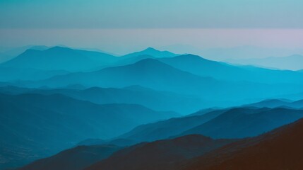 Naklejka premium Blue mountain range with hazy skies in cool tones create layered effect of depth and serenity. Nature's beauty captured in a tranquil landscape.