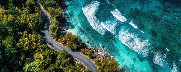 Aerial drone view of winding coastal road beside turquoise ocean with room for overlay
