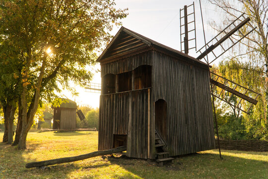 Old vintage wooden wind mills in a backlight in a  Museum of Folk Life and Architecture of Middle Naddnipryanshyna in  Pereyaslav-Khmelnytsky, Ukraine.