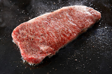鉄板でステーキを焼いているシーン
