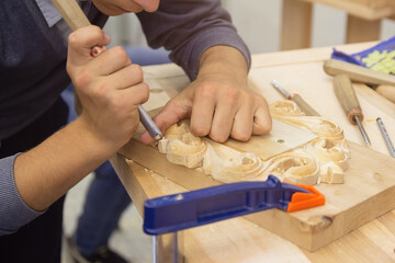 Hands of a master making hand-carved wood