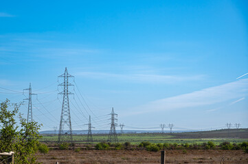 Landscape view of high voltage power lines in the fields on a sunny day, Victoria, Australia