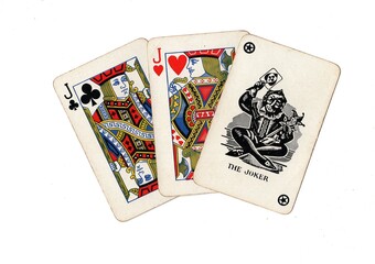 A hand of vintage playing cards showing a joker and two cards of the same value isolated on a white background.