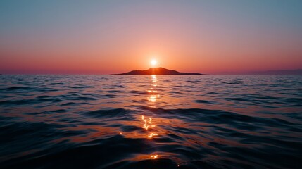 Fototapeta premium Sunset over calm ocean waters with distant island at twilight in serene atmosphere