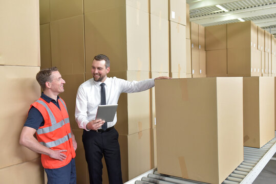 Manager and worker in a warehouse in the logistics sector - transport and processing of orders in trade