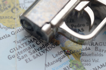 Symbolic Gun Conflict in Central America: Toy Pistol Resting on El Salvador Map
