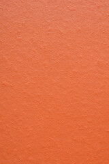 A close-up of a terracotta tile detail with a slightly rough surface and small imperfections, providing a warm and earthy texture background