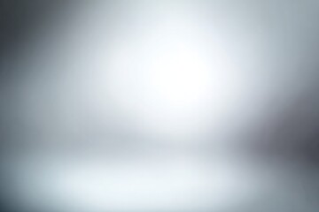 Blurred, abstract grey/white studio backdrop with subtle gradient and soft lighting effect, creating a smooth, uniform background