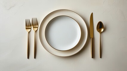 A minimalist table setting displays elegant gold flatware and white plates, creating a sophisticated and refined dining atmosphere.