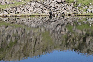 Hillside reflected in a tarn