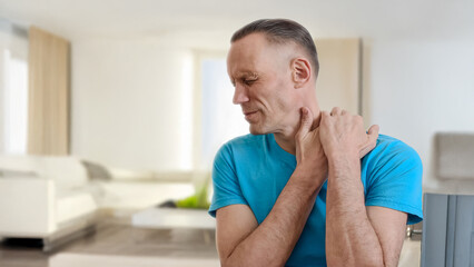 Man suffering from neck pain because of incorrect sitting posture. Adult male in pain, pressing...