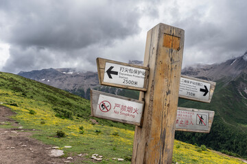 hiker next to an information post, Haizigou Valley, Mount Siguniang National Park, Qionglai Mountains, Sichuan,  China
