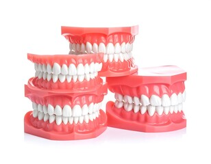 Obraz premium Three pink dental models with white teeth, stacked on a white background