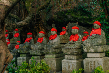 Cute little Ojizosan statues with little red hats in a temple in Japan