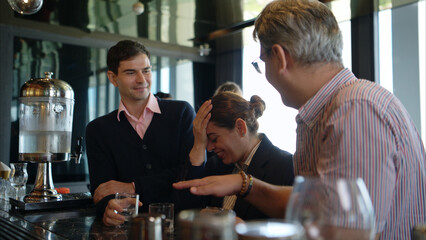 Smiling bartender serving drinks to customers at a modern bar