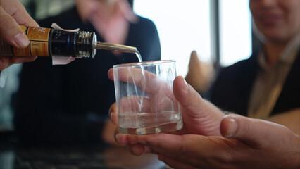Smiling bartender serving drinks to customers at a modern bar