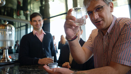 Smiling bartender serving drinks to customers at a modern bar