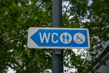 Fototapeta premium A directional sign for a public toilet with icons for male, female, and disabled access, concept of public services and accessibility.