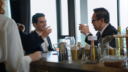 Smiling bartender serving drinks to customers at a modern bar