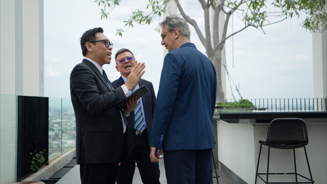 Business team working together on a laptop during an outdoor meeting