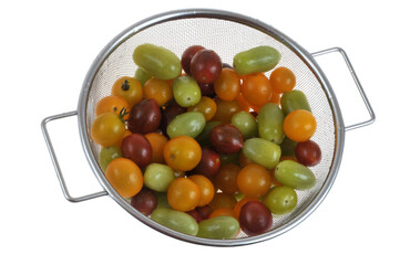 Tomates cerises de différentes couleurs et saveurs dans une passoire vue de dessus en gros plan...