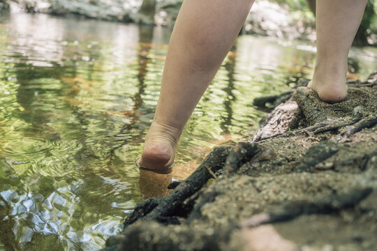 Woman entering river with swollen ankles from lipedema condition