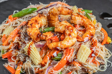 Stir fried rice noodles with shrimp and vegetables served on a plate