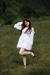Girl in a light white dress in a field on a summer day