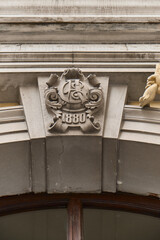 Detailed close-up of a historic stone architectural element on a building facade, featuring...