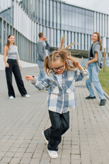 Obraz premium Happy family of mom, dad and two daughters having fun outside