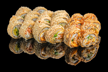 Crispy deep fried sushi rolls with sauce on black background