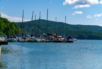 Bieszczady Solina Lake, marina with moored sailboats and yachts against green mountains, summer...