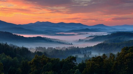 Obraz premium Mountain sunrise with fog-filled valley & distant ranges under colorful cloudscape