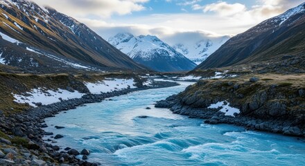 Obraz premium Majestic mountains cascading with snow bordering tranquil stream in valley
