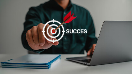 Person holding a target with arrow and the word succes next to a laptop success goal