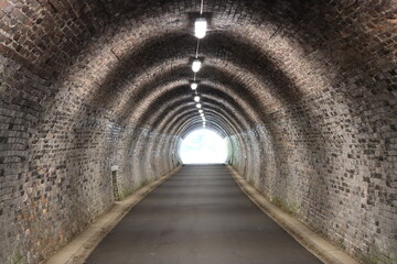 Obraz premium View along a pedestrian and cycle tunnel on a disused railway line