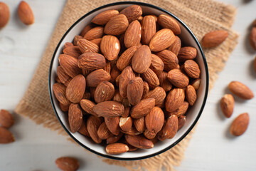 Almonds in white bowl on white background. Perfect for recipes, articles or any cooking content