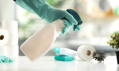 Bathroom cleaning concept with hand with disinfectant and wc products