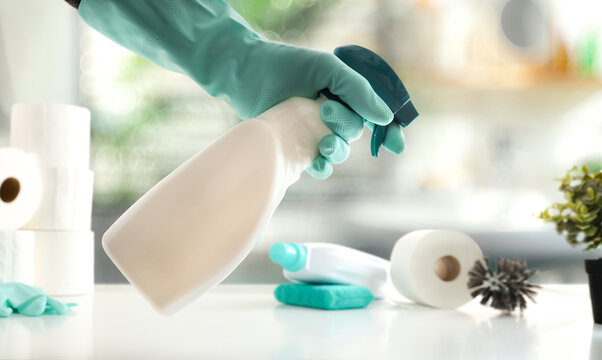 Bathroom cleaning concept with hand with disinfectant and wc products