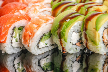 Close-up of assorted sushi rolls with avocado, cream cheese and sauce