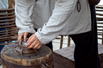 Blacksmith works hammer minting ancient coin during historical reconstruction amateur festiva