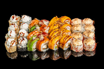 Assorted sushi rolls with cream cheese, mango topping, seafood, and sesame seeds on black background